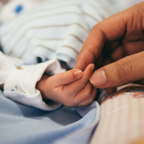 newborn baby holding mom's hand
