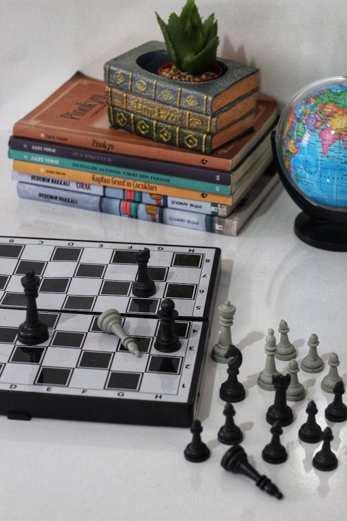 Chess on Desk with Books and Globe